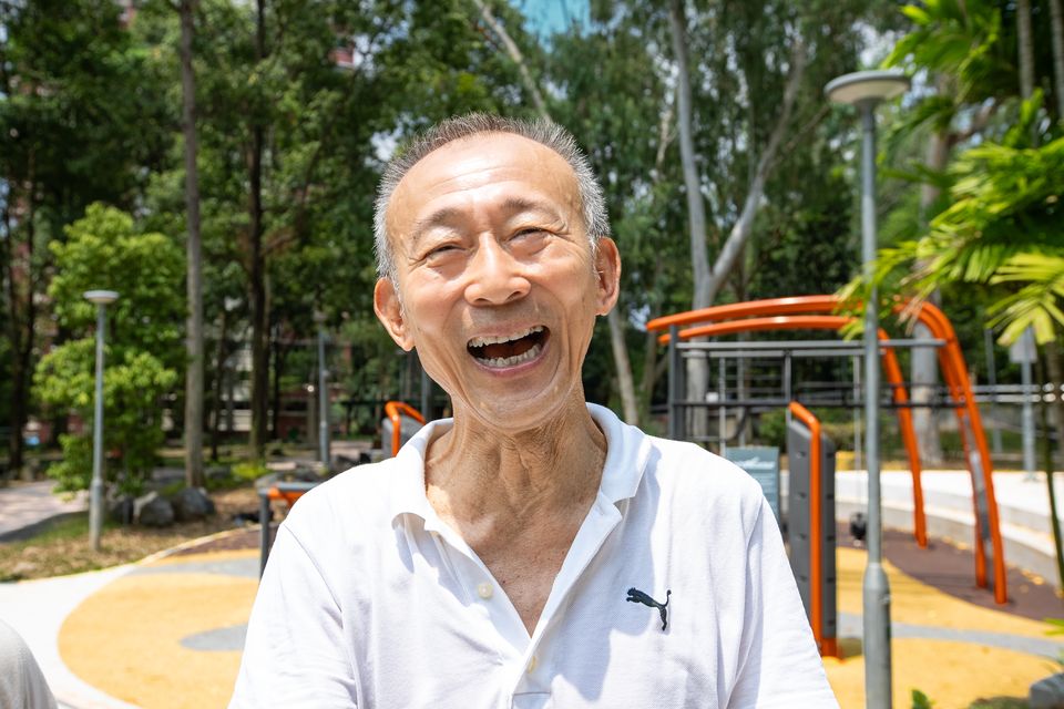 An older man laughs beside new outdoor fitness equipment in Pasir Ris