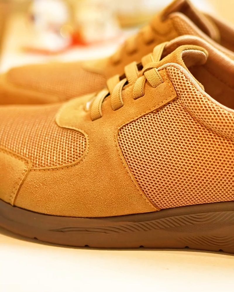 A tan sneaker on display at a store opening