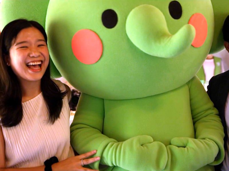 Jenny, the park manager, laughs beside the park's new elephant mascot