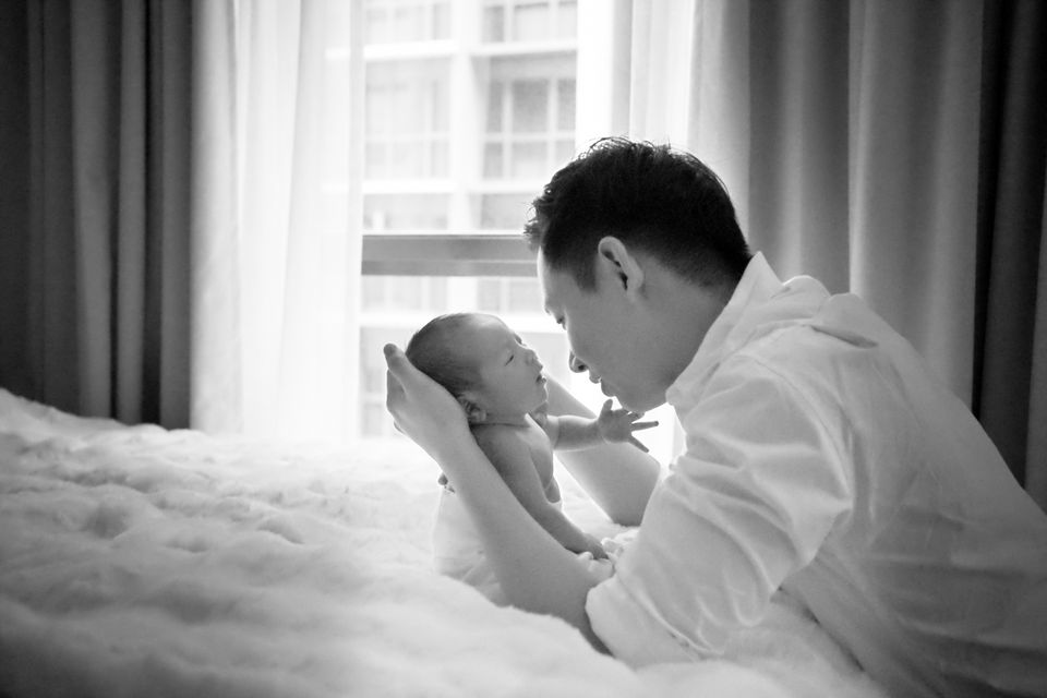 Black and white photograph of a father holding his newborn daughter