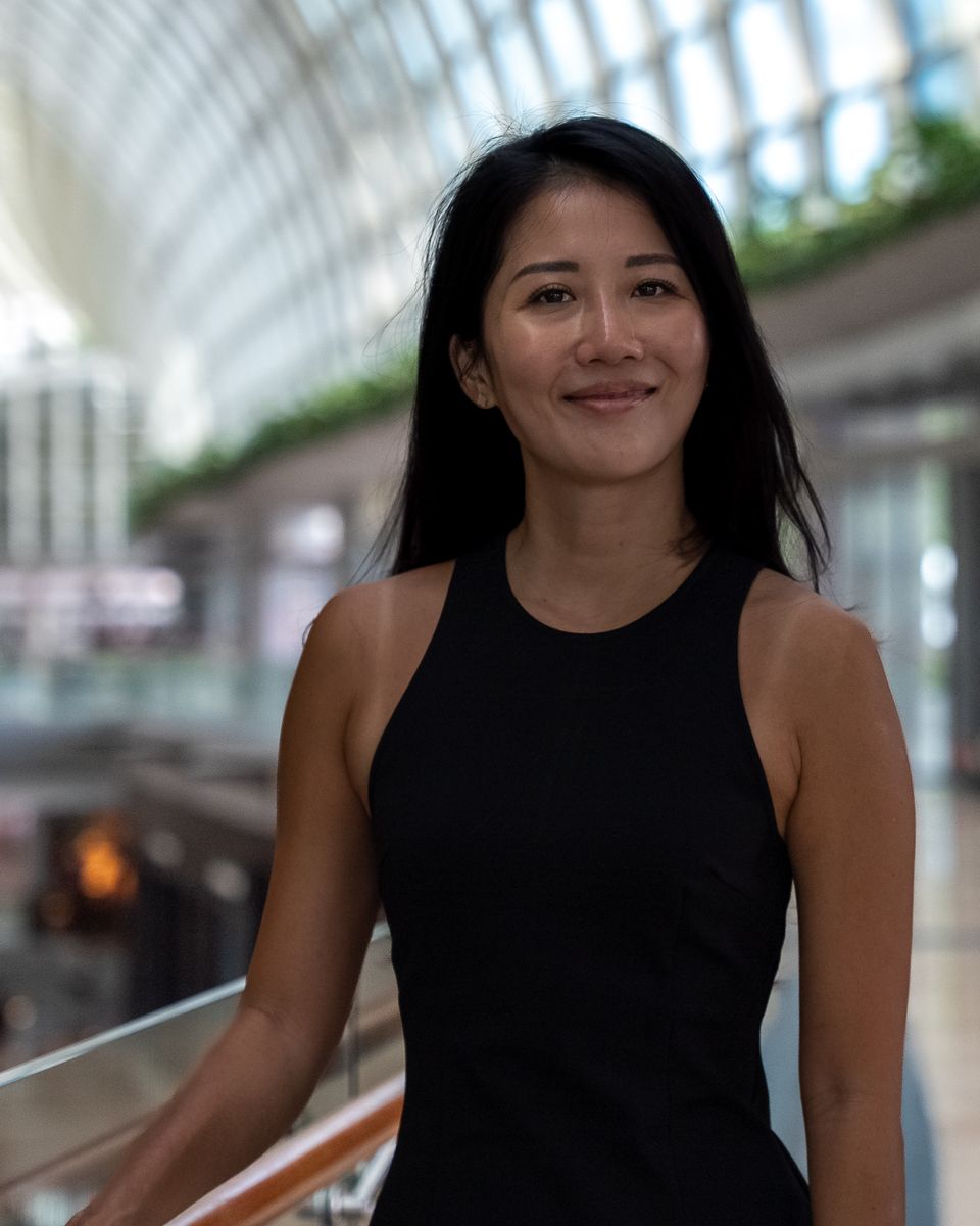 Brand portrait of a woman in a black dress in a bright atrium