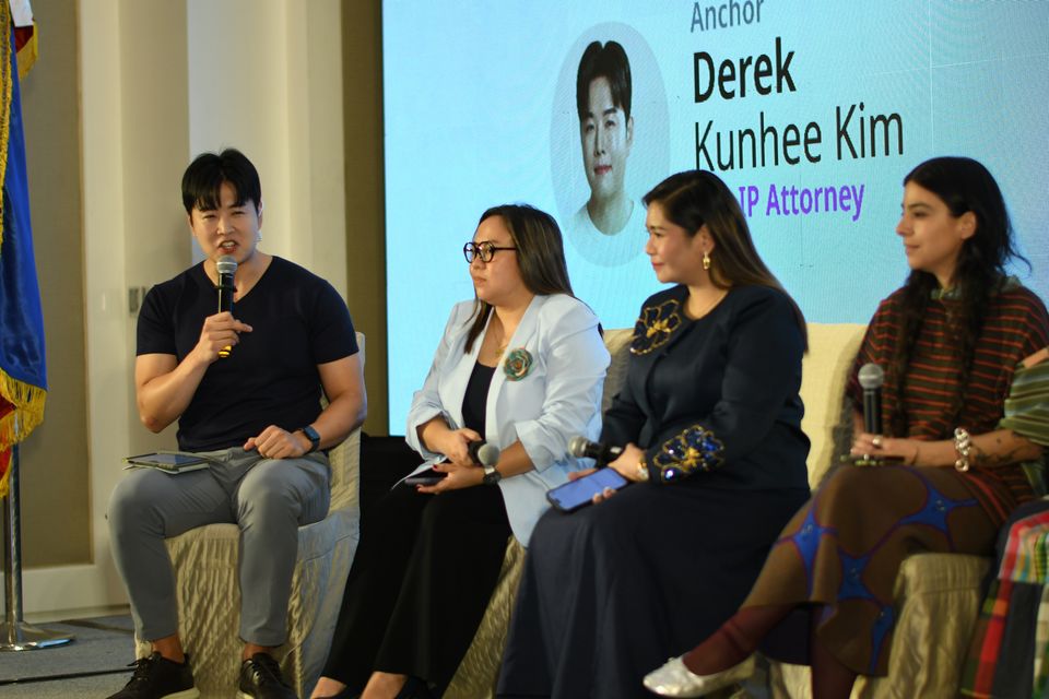 The anchor, Derek Kunhee Kim, speaks with his name on the LED wall, beside Janice Reyes Tejano, Doreen Odvina Malbas and Laura Acevedo Trillos