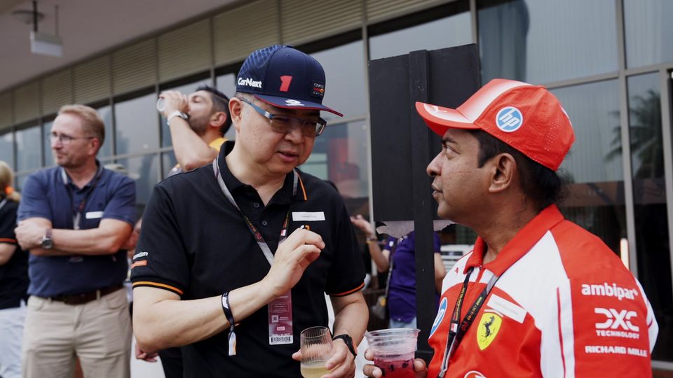 Guests in team caps talk in the Ascentium lounge on race weekend