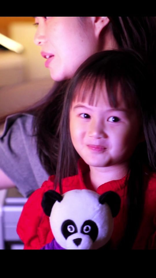 A mother and her small daughter, who holds a toy panda, at the music school