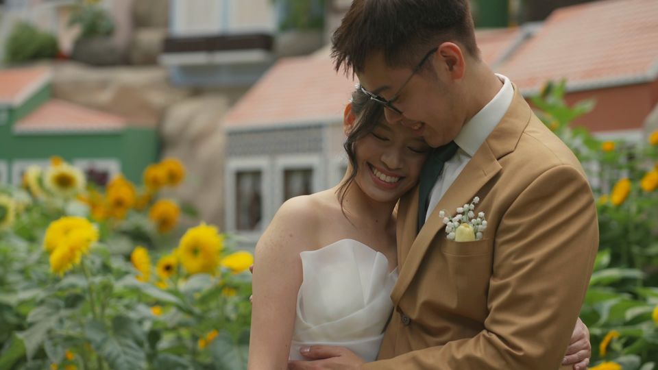 Bride and groom embrace among sunflowers in the Flower Dome