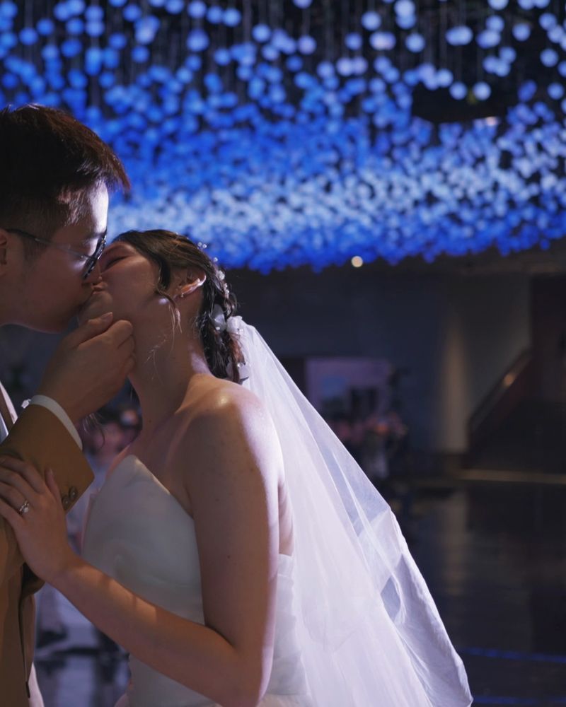 The couple kiss under blue lights